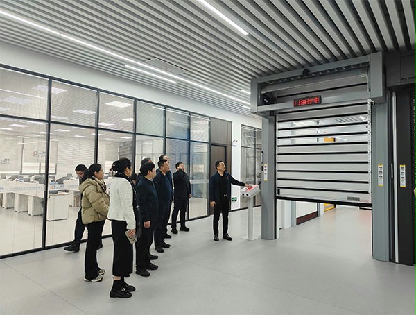 上图为：午夜福利三级片门业董事长杨元嘉为领导们演示高端工业门产品在工业物联网中的应用